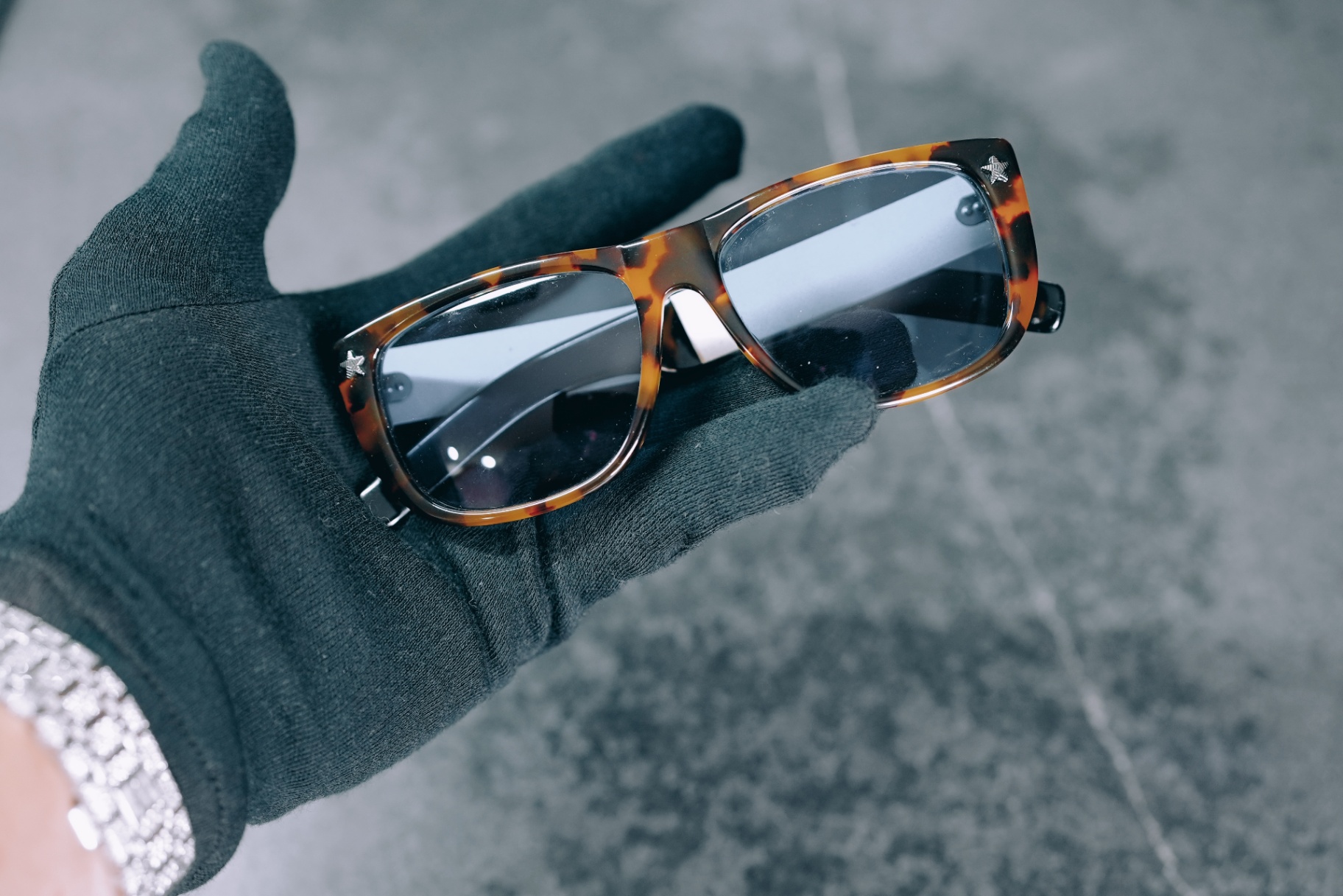 Handheld angled view of tortoise rectangular Jean Paul Gaultier frame