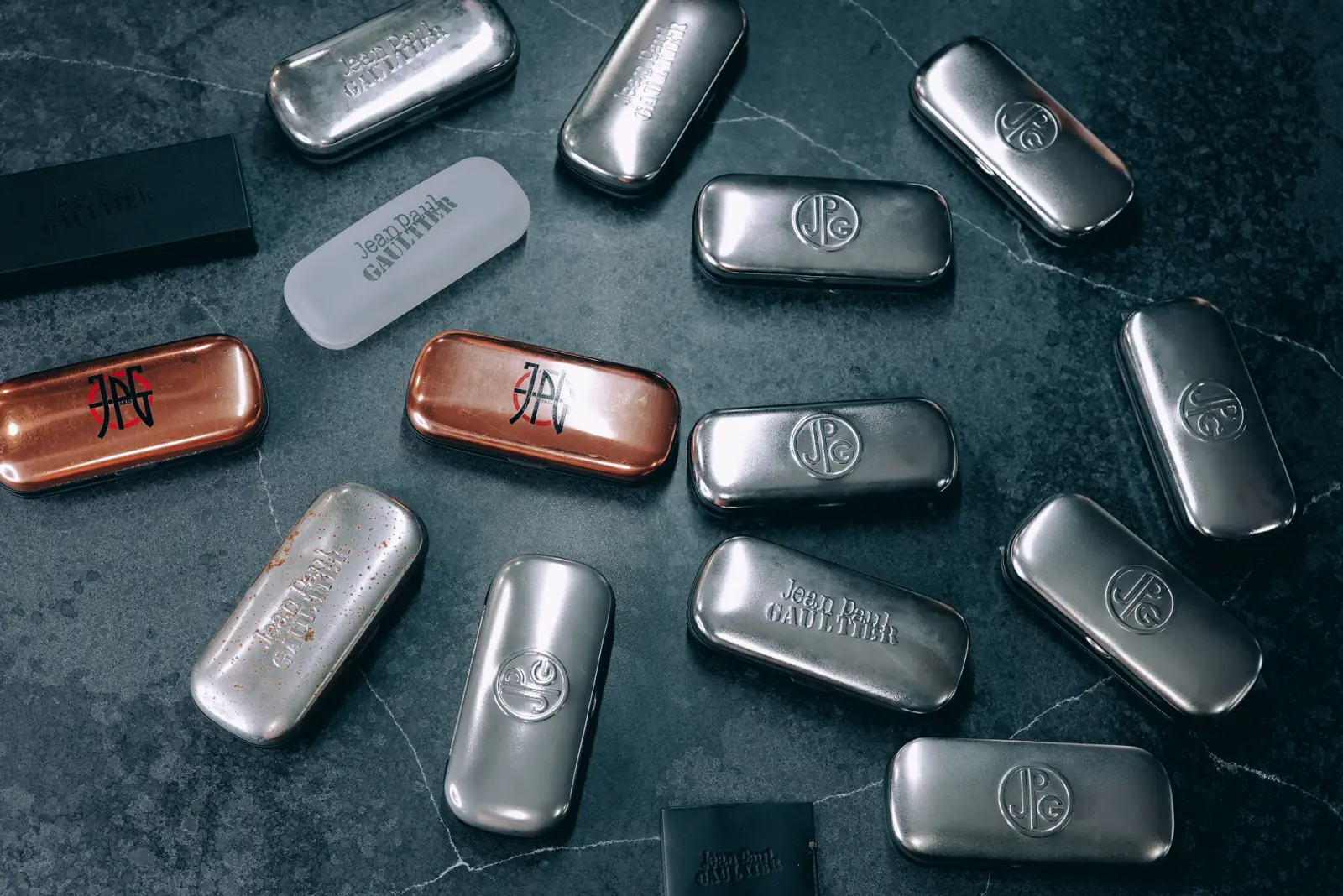 Rare vintage designer eyewear cases arranged on dark stone — 858Vintage